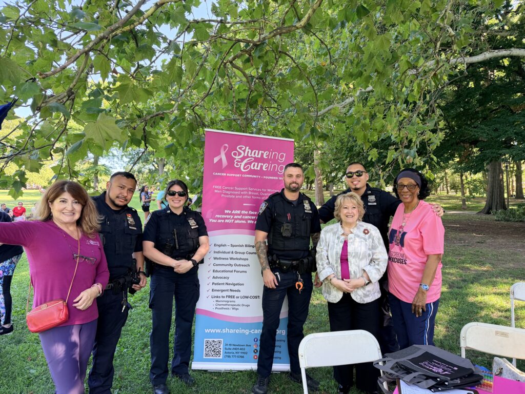 women standing with police officers in front of a sign in a park