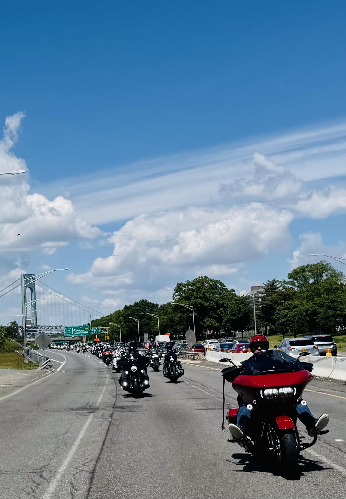 A line of motorcycles on a busy highway
