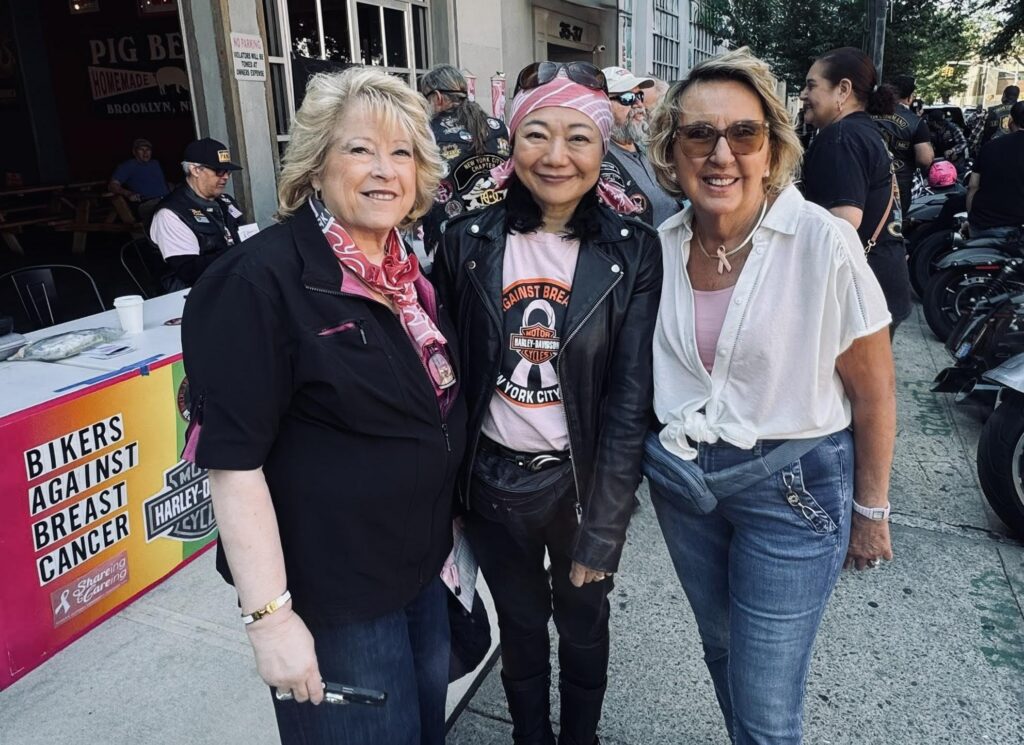 Three women smiling at the 2026 Bikers Against Breast Cancer ride