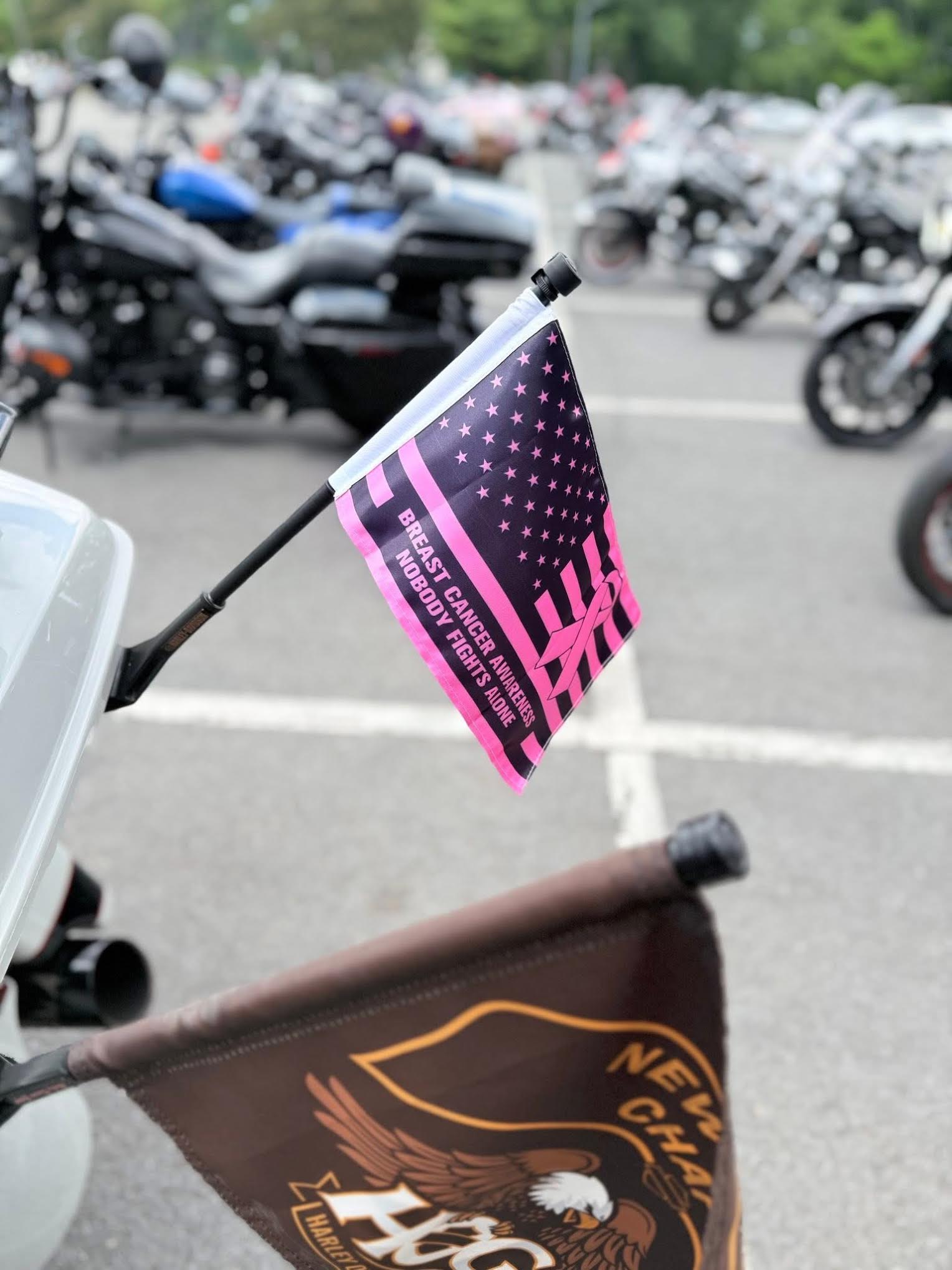 A pink and black United States flag with breast cancer ribbon