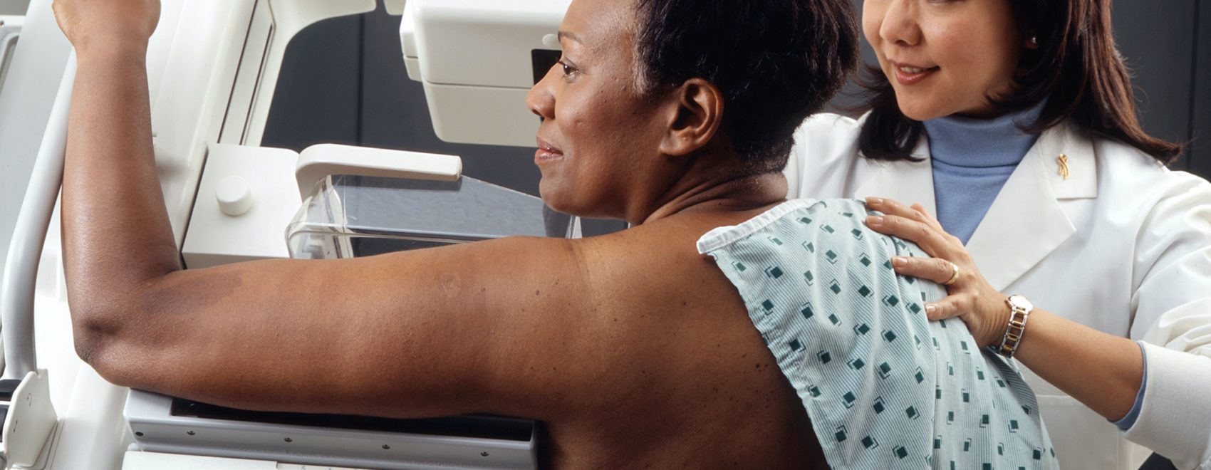 nurse helping patient with mammogram machine