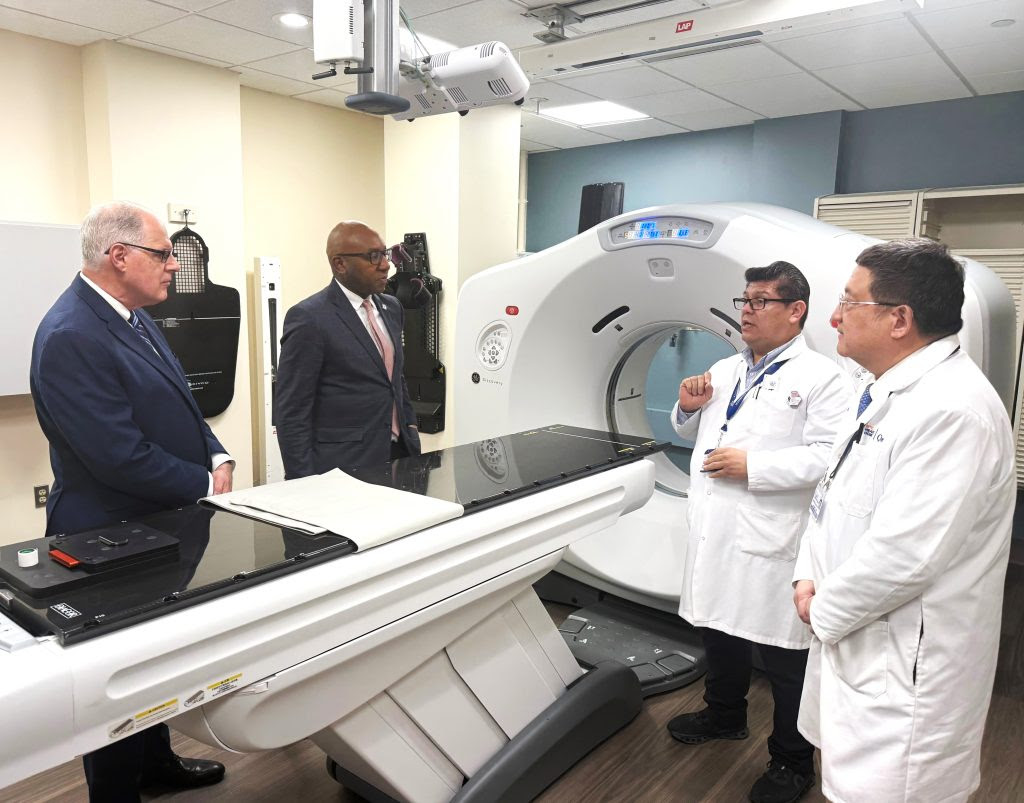 doctors and men in suits stand by new hospital equipment